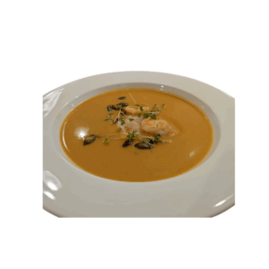 Pumpkin cream soup with ginger, coconut milk, and king prawns